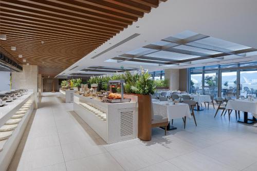 a restaurant with white tables and chairs and windows at Concorde Tower Hotel & Casino in North Nicosia