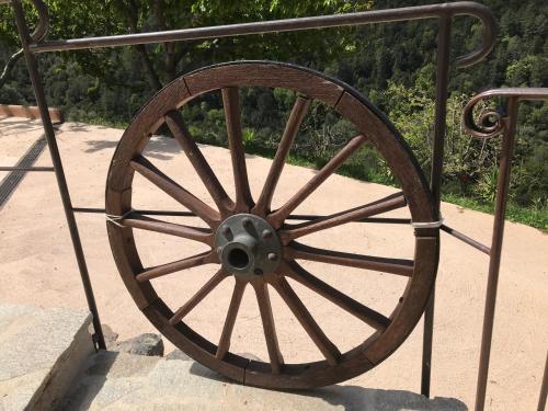 a wooden wagon wheel on a metal railing at Gîte A Funtana Montestremo, Balagne, Haute Corse in Manso