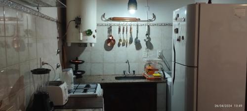 cocina con fregadero y nevera en Mi casita en Tandil