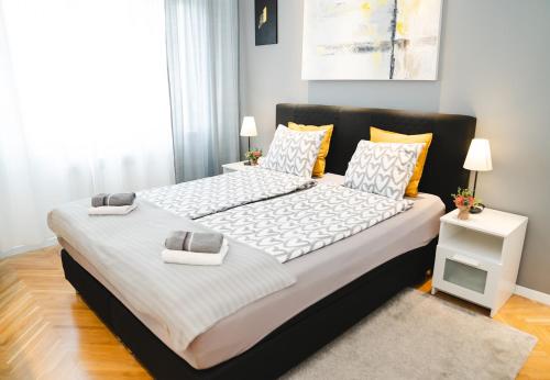 een slaapkamer met een groot bed met witte lakens bij Casa de Dinca, 2 bedroom, big balcony, free parking zone in Zagreb