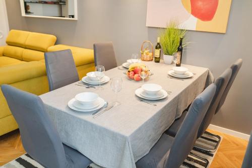 comedor con mesa con sillas y sofá amarillo en Casa de Dinca, 2 bedroom, 6 persons, free parking zone, en Zagreb