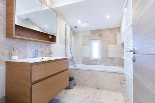 une salle de bain avec un lavabo et une baignoire dans l'établissement Duplex dans les Pins, à Saint-Raphaël