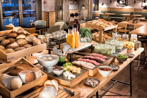une table remplie de beaucoup de différents types de pain dans l'établissement Adina Apartment Hotel Copenhagen, à Copenhague