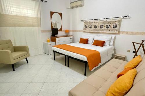 1 dormitorio con cama, silla y espejo en B&B Mare Monti Miniere, en Iglesias