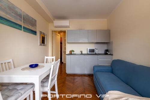 a living room with a blue couch and a table at Paraggi Apartment by PortofinoVip in Paraggi