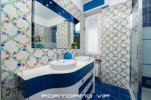 La salle de bains est pourvue de 2 lavabos et d'un miroir. dans l'établissement Paraggi Apartment by PortofinoVip, à Paraggi