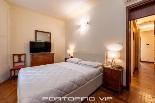a bedroom with a large bed and a television at Paraggi Apartment by PortofinoVip in Paraggi