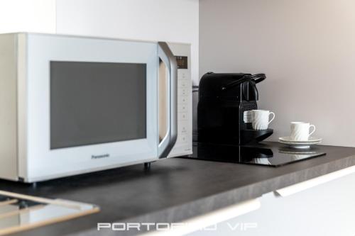 a microwave sitting on a counter with two coffee cups at Paraggi Apartment by PortofinoVip in Paraggi
