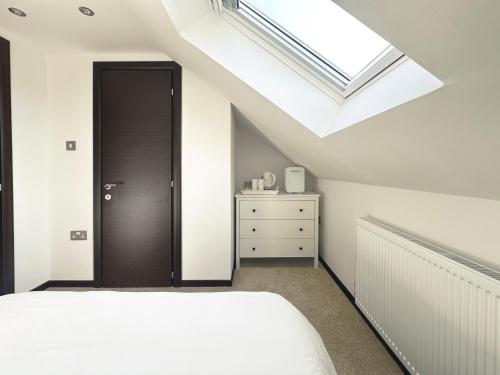 a bedroom with a bed and a skylight at The Barn in Chichester