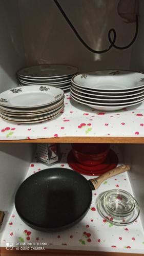 a stack of plates and plates on a shelf at Kuća Donji Park in Bečej