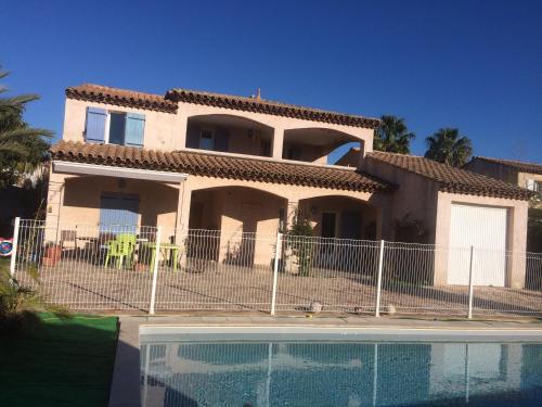 une maison avec une clôture à côté d'une piscine dans l'établissement Relax, à Saint-Cyr-sur-Mer