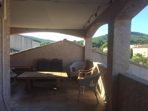 un patio avec une table et des chaises sur un balcon dans l'établissement Relax, à Saint-Cyr-sur-Mer
