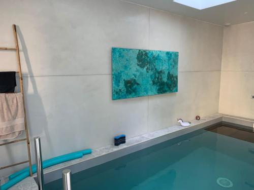 - une piscine dans une pièce ornée d'une peinture murale dans l'établissement Maison de vacances piscine intérieure La Rochelle, à La Rochelle