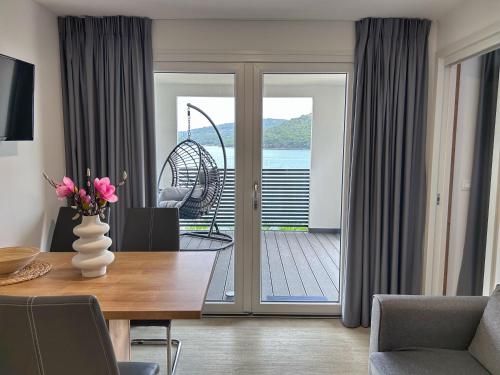 - une salle à manger avec une table et une vue sur l'océan dans l'établissement Bella Homes Camping, à Tisno