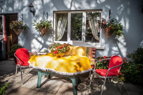 una mesa con sillas rojas y una mesa con flores. en Herlihy's, Half-Way-House, en Farranfore
