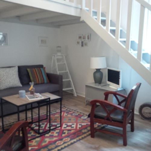 un salon avec un canapé et une table dans l'établissement Le Malraux, à Sarlat-la-Canéda