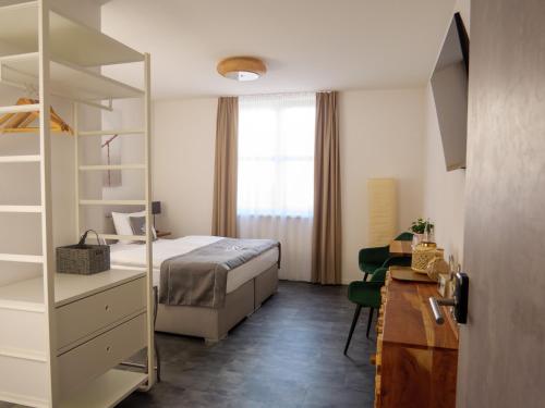1 dormitorio con 1 cama, vestidor y escritorio en Hotel Sleep & Dream Nähe Europa Park und Rulantica en Ringsheim