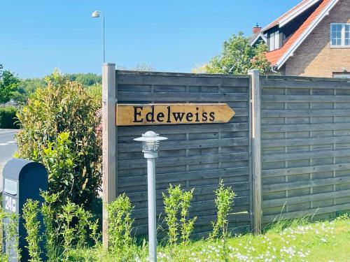 Ein Schild, auf dem die Kante auf einem Zaun steht. in der Unterkunft Lejlighed Edelweiss in Svendborg