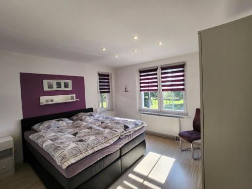 a bedroom with a bed and a chair in it at Ferienhaus Naturpur Chorin in Chorin