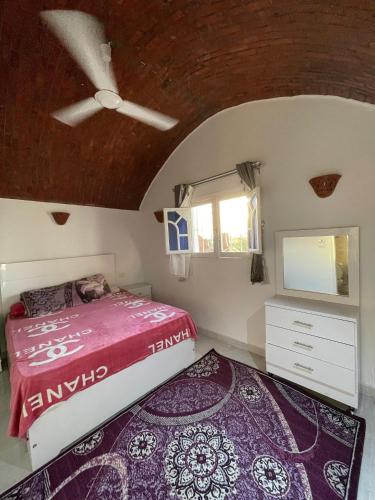 een slaapkamer met een bed en een televisie aan het plafond bij Julia House in Luxor