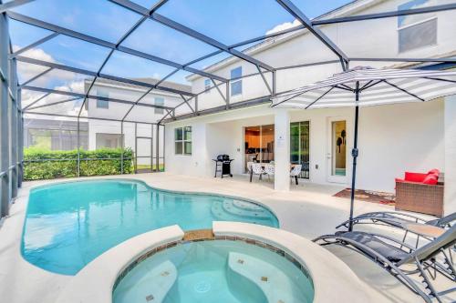 an indoor swimming pool with a glass roof at 5BR Family Home with Pool & Hot Tub Near Disney in Kissimmee