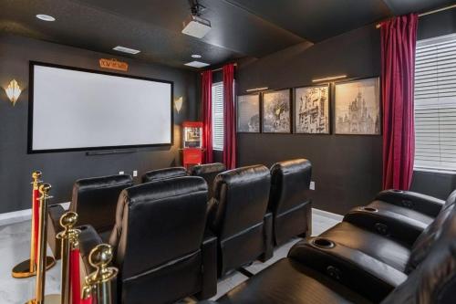 a cinema room with leather chairs and a screen at 5BR Family Home with Pool & Hot Tub Near Disney in Kissimmee