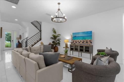 a living room with a couch and chairs and a tv at 5BR Family Home with Pool & Hot Tub Near Disney in Kissimmee