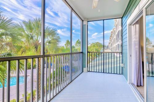 Un balcón con vista a la piscina y palmeras. en 3BR Condo with Hot Tub and Pool - Near Disney, en Orlando