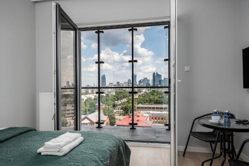 a bedroom with a bed and a view of a city at Warsaw Modern Stay Apartamenty Kasprzaka 29 in Warsaw