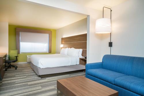 a hotel room with a bed and a couch at Holiday Inn Express & Suites Rocky Mount Smith Mountain Lake by IHG in Rocky Mount