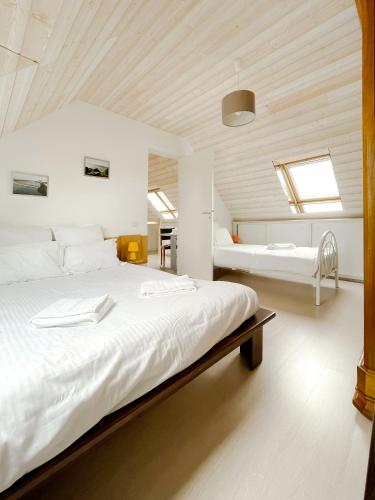 une chambre avec un grand lit blanc dans une pièce dans l'établissement Gîte St Ylé, à Pontorson