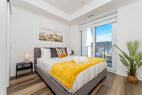 a bedroom with a bed with two towels on it at Stylish 2BR Condo - Balcony - Stunning City View in Kitchener