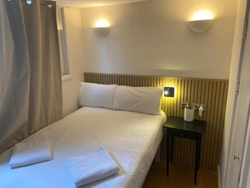 a bed with two pillows on it in a room at Exhibition Court Hotel 4 in London