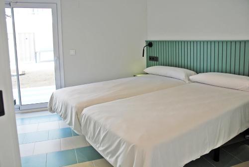 two beds sitting next to each other in a room at Apartamentos Sunway Atlanta in Sitges