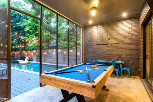 a pool table in a room with a swimming pool at Backyard Pool Oasis - Rainey Street - 6 min walk in Austin
