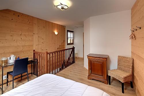 une chambre avec un lit, un bureau et une chaise dans l'établissement Pré Fleuri 1 - Appt vue lac et montagne, à Gérardmer