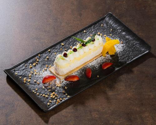 a piece of cake sitting on a black plate at Zlatni Zalaz,Apartments,Supetarska Draga in Supetarska Draga