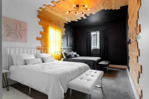 1 Schlafzimmer mit 2 Betten in einem Zimmer mit schwarzen Wänden in der Unterkunft Insa Worthy Two-Home Retreat - Fire Pit, Hot Tub in Austin