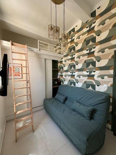 - un salon avec un canapé bleu et un mur dans l'établissement Studio Cosy au cœur d’Aix et & Cours Mirabeau, à Aix-en-Provence