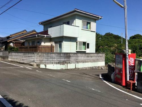a white house on the side of a street at オーシャンビューで海水浴が出来てカフェも近い貸し切り宿ウミトミント in Otsuki
