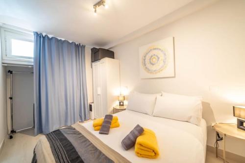 a bedroom with a large white bed with yellow pillows at Paraiso maspalomas sunset by CALIMA HOMES in San Bartolomé
