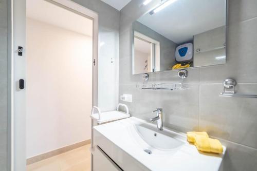 a bathroom with a sink and a mirror at Paraiso maspalomas sunset by CALIMA HOMES in San Bartolomé