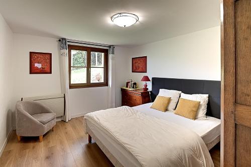 une chambre avec un lit, une chaise et une fenêtre dans l'établissement Pré Fleuri 2 - Vue Lac et Montagne, à 600m du lac, à Gérardmer