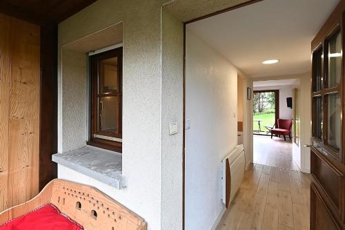- un couloir d'une maison avec un lit et une fenêtre dans l'établissement Pré Fleuri 2 - Vue Lac et Montagne, à 600m du lac, à Gérardmer