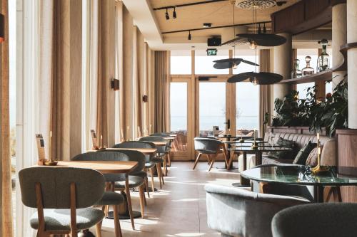 una fila de mesas y sillas en un restaurante en Boutique Hotel Blendin Bloemendaal aan Zee, en Overveen