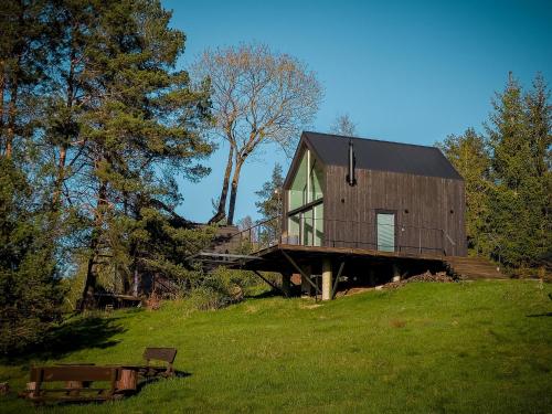 ein Holzhaus auf einem Grashügel in der Unterkunft Dom na Kaszubach Lektura in Fingrowa Huta