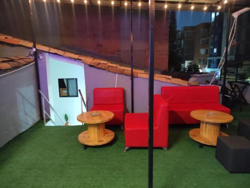 a patio with red chairs and tables and lights at Absolute Hotel & Hostel Boutique in Medellín