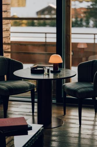 a table with two chairs and a lamp on it at Aethos Monterosa in Champoluc