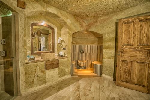 a large bathroom with a shower and a wooden door at Utopia Cave Cappadocia in Urgup