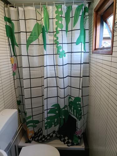 a bathroom with a shower curtain with plants on it at Vakantiehuisje Veluwe, Alleen Voor Recreatie in Putten